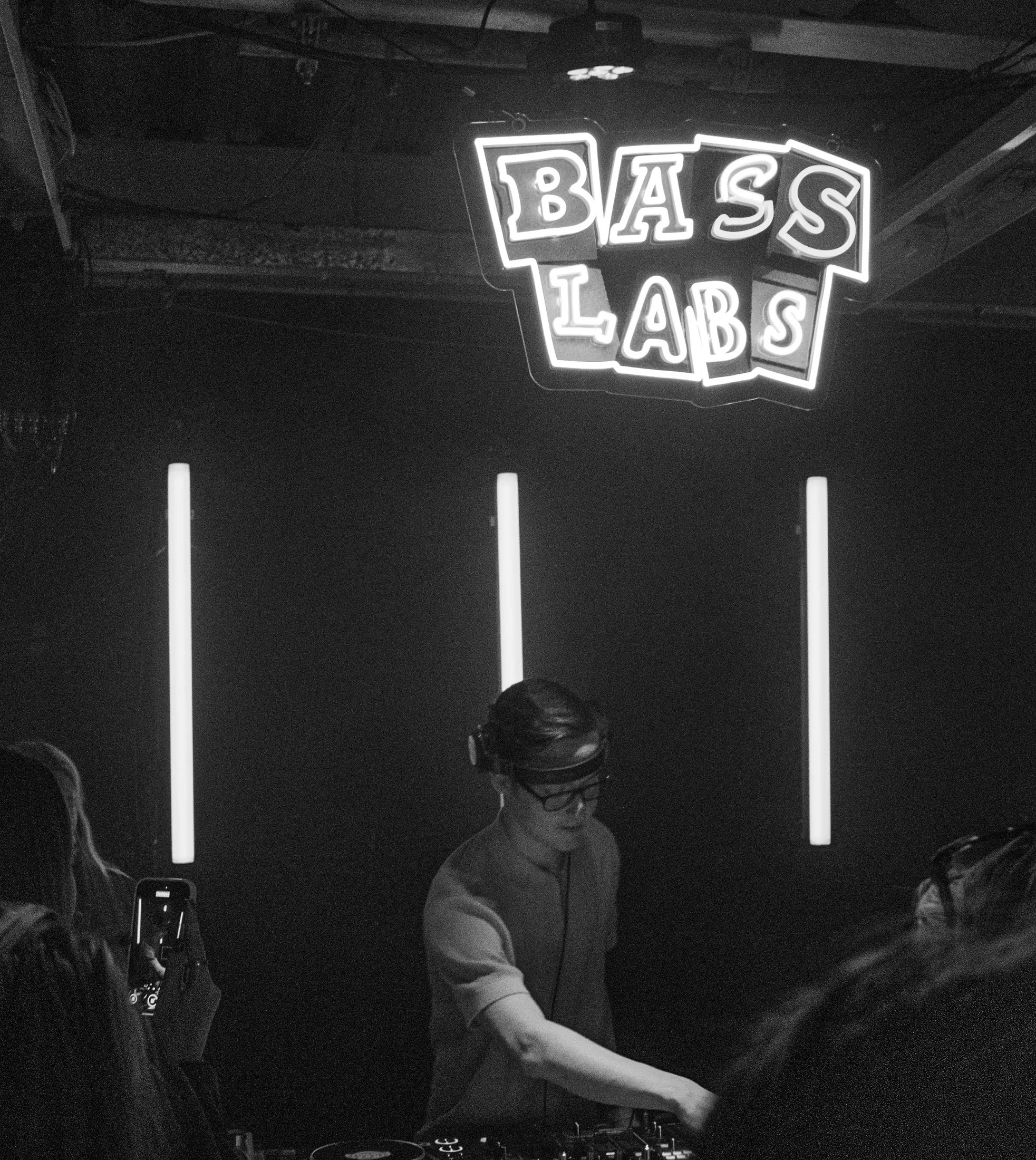 DJ performing under the Bass Labs sign at Sunset Underground